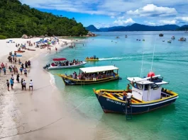 A imagem mostra embarcações realizando o desembarque de visitantes na Ilha do Campeche, ilustrando o transporte turístico que atende a operação de acesso e visitação ao local.
