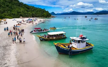 Florianópolis define regras para transporte e visitação à Ilha do Campeche A imagem mostra embarcações realizando o desembarque de visitantes na Ilha do Campeche, ilustrando o transporte turístico que atende a operação de acesso e visitação ao local.