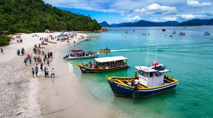 Florianópolis define regras para transporte e visitação à Ilha do Campeche A imagem mostra embarcações realizando o desembarque de visitantes na Ilha do Campeche, ilustrando o transporte turístico que atende a operação de acesso e visitação ao local.