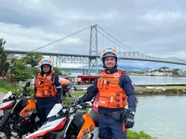 Motolâncias do SAMU posicionadas em Florianópolis, com profissionais equipados ao lado das motocicletas, destacando o reforço ao atendimento de urgência e emergência em áreas de difícil acesso e trânsito intenso.