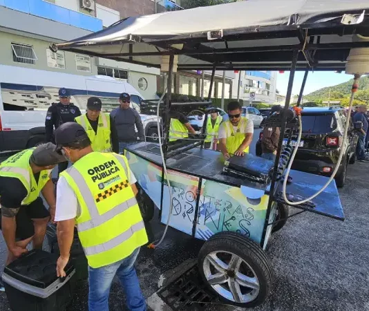 Agentes da Operação Verão fiscalizam ambulantes na praia, garantindo segurança e cumprimento das normas.