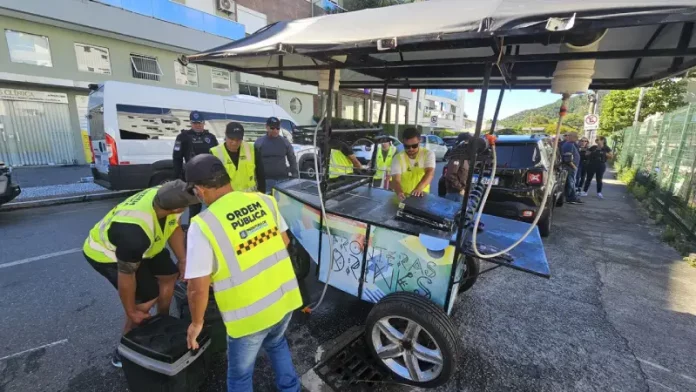 Operação Verão Florianópolis Agentes da Operação Verão fiscalizam ambulantes na praia, garantindo segurança e cumprimento das normas.