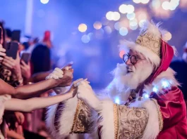 Desfile de Natal reúne mais de 300 artistas, Papai Noel e luzes da aurora boreal em Florianópolis Papai Noel cumprimenta o público durante o Desfile de Natal, interagindo com famílias e celebrando a magia da festa.