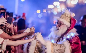Desfile de Natal reúne mais de 300 artistas, Papai Noel e luzes da aurora boreal em Florianópolis Papai Noel cumprimenta o público durante o Desfile de Natal, interagindo com famílias e celebrando a magia da festa.