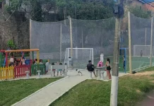 Praça Andréia Dolisete dos Santos com campo de grama sintética e playground, usada por moradores para lazer, esporte e convivência no bairro Monte Cristo.