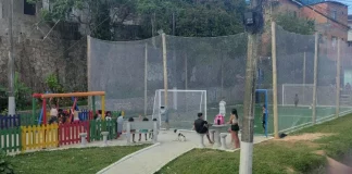 Praça Andréia Dolisete dos Santos com campo de grama sintética e playground, usada por moradores para lazer, esporte e convivência no bairro Monte Cristo.