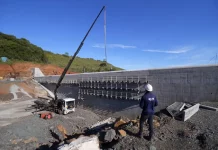 Programa Energia Boa reúne 21 hidrelétricas em construção em Santa Catarina Pessoa com capacete observa obra de usina hidrelétrica em construção, ilustrando o avanço das estruturas ligadas ao Programa Energia Boa.