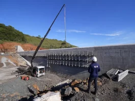 Programa Energia Boa reúne 21 hidrelétricas em construção em Santa Catarina Pessoa com capacete observa obra de usina hidrelétrica em construção, ilustrando o avanço das estruturas ligadas ao Programa Energia Boa.