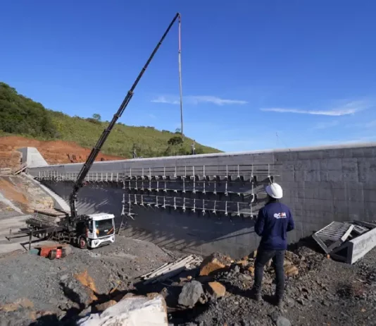 Programa Energia Boa reúne 21 hidrelétricas em construção em Santa Catarina Pessoa com capacete observa obra de usina hidrelétrica em construção, ilustrando o avanço das estruturas ligadas ao Programa Energia Boa.
