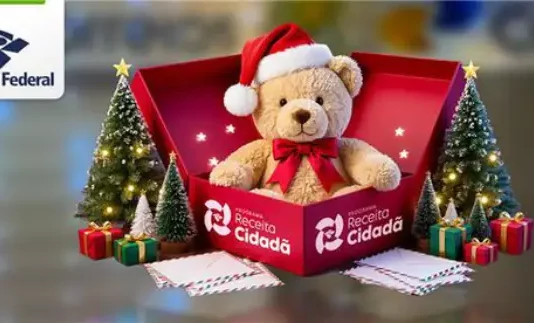 Imagem institucional da Receita Federal com urso de pelúcia usando gorro de Natal dentro de uma caixa da campanha Receita Cidadã, ao lado de árvores natalinas e presentes, simbolizando doações para o Papai Noel dos Correios.
