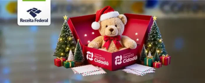 Imagem institucional da Receita Federal com urso de pelúcia usando gorro de Natal dentro de uma caixa da campanha Receita Cidadã, ao lado de árvores natalinas e presentes, simbolizando doações para o Papai Noel dos Correios.