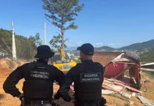 agentes da Guarda Municipal e da Guarda Municipal Ambiental acompanham a demolição de construções irregulares para garantir segurança e cumprimento da ação