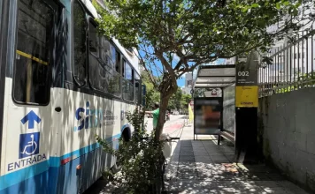 Fim do pagamento em dinheiro nos ônibus de Florianópolis entra em vigor em janeiro, acelera migração e garante benefícios Imagem mostra ônibus do transporte coletivo de Florianópolis em ponto de embarque, ilustrando o fim do pagamento em dinheiro e a transição para meios eletrônicos no sistema.
