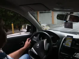 Instrutor de autoescola conduzindo veículo durante aula prática, demonstrando técnicas de direção e segurança no trânsito.