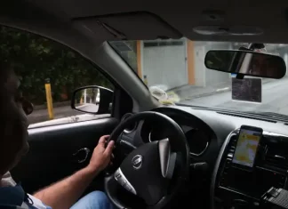 Instrutor de autoescola conduzindo veículo durante aula prática, demonstrando técnicas de direção e segurança no trânsito.