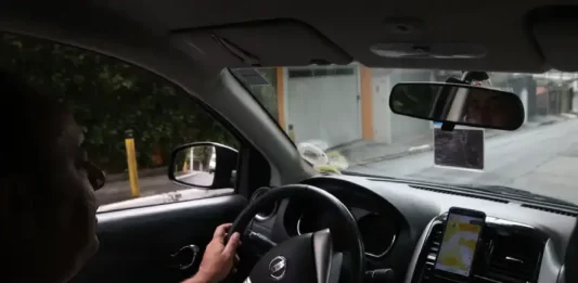 Instrutor de autoescola conduzindo veículo durante aula prática, demonstrando técnicas de direção e segurança no trânsito.