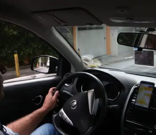 Instrutor de autoescola conduzindo veículo durante aula prática, demonstrando técnicas de direção e segurança no trânsito.