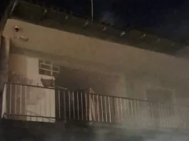 Imagem mostra a fachada de uma residência atingida por incêndio, com fumaça saindo do imóvel durante atendimento do Corpo de Bombeiros em São José.