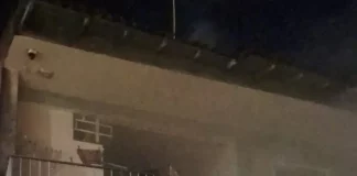 Imagem mostra a fachada de uma residência atingida por incêndio, com fumaça saindo do imóvel durante atendimento do Corpo de Bombeiros em São José.