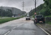 Carros passam por trecho alagado em São José durante a chuva desta terça-feira, ilustrando os impactos do volume intenso de água nas vias do município.