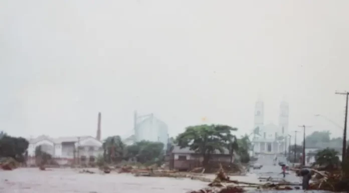 30 anos da Enchente de Natal: tragédia que marcou Santa Catarina Imagem mostra áreas urbanas de Nova Veneza alagadas durante a Enchente de Natal, evidenciando o impacto das cheias sobre ruas, casas e a infraestrutura da cidade.