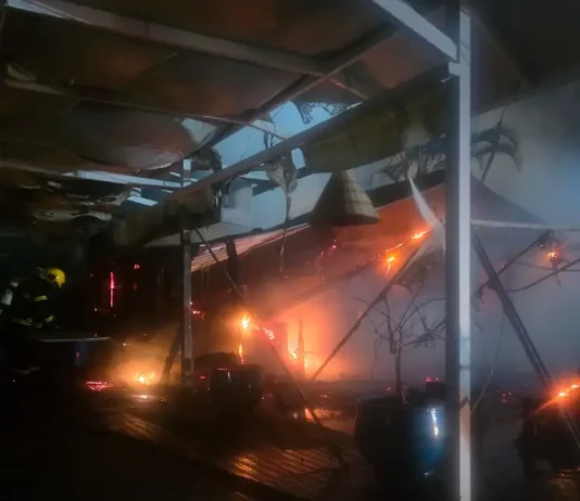 Incêndio destrói parte de restaurante em marina no Norte da Ilha, em Florianópolis Foto mostra bombeiros atuando no combate ao incêndio dentro do restaurante instalado em uma marina, destacando as chamas ainda ativas e a destruição parcial da estrutura.