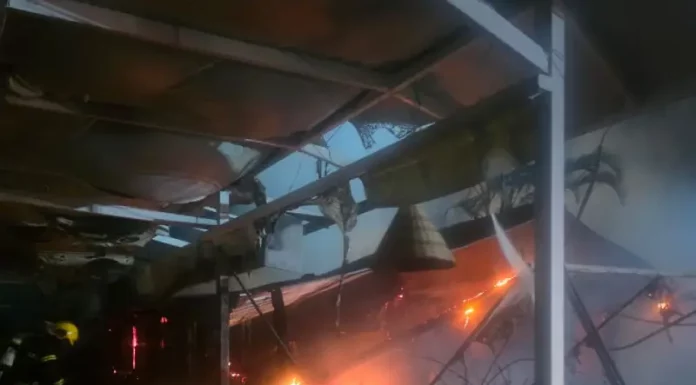 Incêndio destrói parte de restaurante em marina no Norte da Ilha, em Florianópolis Foto mostra bombeiros atuando no combate ao incêndio dentro do restaurante instalado em uma marina, destacando as chamas ainda ativas e a destruição parcial da estrutura.