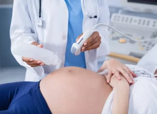 Foto mostra uma gestante em exame de ultrassom, ilustrando cuidados do pré-natal e a humanização da assistência obstétrica.