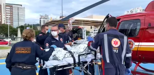 Equipe do serviço aeromédico do Samu realiza atendimento de emergência e prepara paciente para transporte aéreo, ilustrando o uso do Programa Sangue Total no atendimento pré-hospitalar em Santa Catarina.