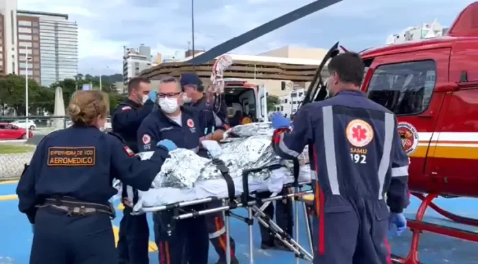 Equipe do serviço aeromédico do Samu realiza atendimento de emergência e prepara paciente para transporte aéreo, ilustrando o uso do Programa Sangue Total no atendimento pré-hospitalar em Santa Catarina.