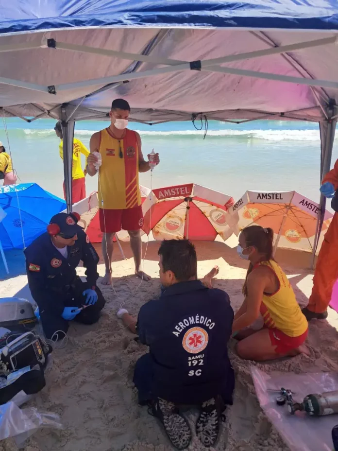 Equipe de socorristas tentando reanimar homem que sofreu mal súbito na Praia dos Ingleses
