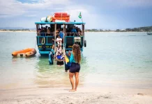 Florianópolis abre credenciamento para transporte à Ilha do Campeche para a temporada 2025/2026 Embarcação de transporte turístico desembarca passageiros na Ilha do Campeche, ilustrando o acesso de visitantes à unidade de conservação.