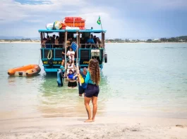 Florianópolis abre credenciamento para transporte à Ilha do Campeche para a temporada 2025/2026 Embarcação de transporte turístico desembarca passageiros na Ilha do Campeche, ilustrando o acesso de visitantes à unidade de conservação.