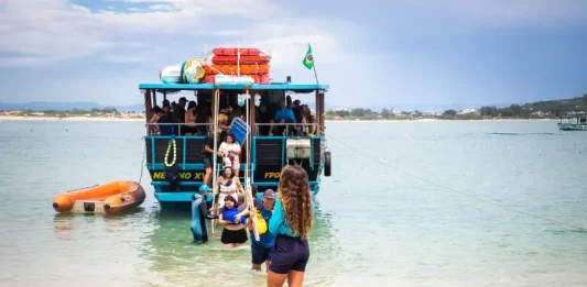 Florianópolis abre credenciamento para transporte à Ilha do Campeche para a temporada 2025/2026 Embarcação de transporte turístico desembarca passageiros na Ilha do Campeche, ilustrando o acesso de visitantes à unidade de conservação.