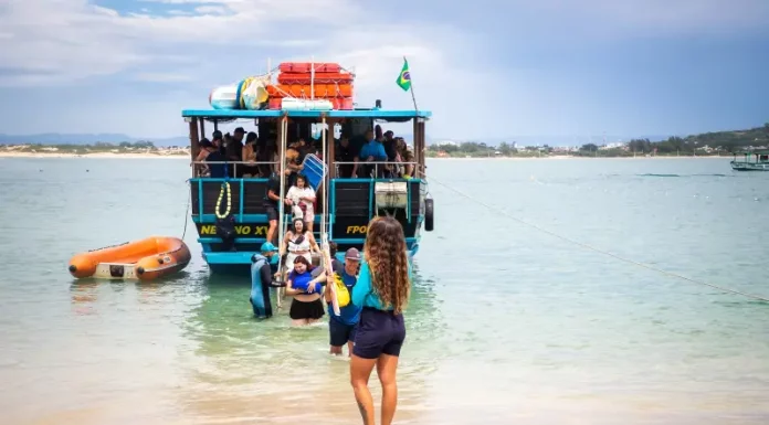 Florianópolis abre credenciamento para transporte à Ilha do Campeche para a temporada 2025/2026 Embarcação de transporte turístico desembarca passageiros na Ilha do Campeche, ilustrando o acesso de visitantes à unidade de conservação.