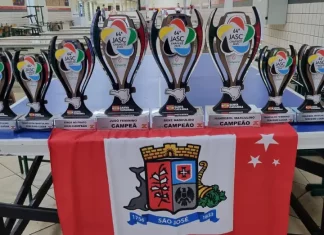 Conjunto de troféus conquistados por São José no Jasc expostos sobre uma mesa, destacando os resultados e o desempenho das equipes do município.