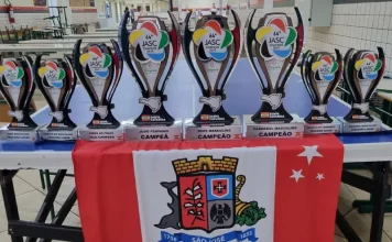 Conjunto de troféus conquistados por São José no Jasc expostos sobre uma mesa, destacando os resultados e o desempenho das equipes do município.