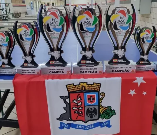 Conjunto de troféus conquistados por São José no Jasc expostos sobre uma mesa, destacando os resultados e o desempenho das equipes do município.