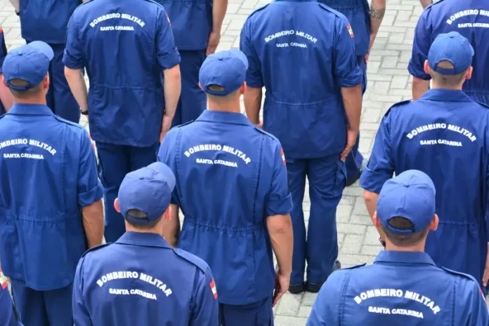 Bombeiros Grupo de bombeiros militares de Santa Catarina, vistos de costas e uniformizados, reunidos em formação, representando o efetivo do Corpo de Bombeiros Militar de Santa Catarina e ilustrando a abertura do processo seletivo para o Serviço Militar Estadual Temporário (SEMET), que visa reforçar as atividades operacionais da corporação em diversas regiões do estado.