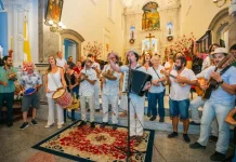 Grupo de Terno de Reis se apresenta em espaço público, ilustrando a tradição cultural e a celebração do encerramento do ciclo natalino em Florianópolis.