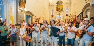 Grupo de Terno de Reis se apresenta em espaço público, ilustrando a tradição cultural e a celebração do encerramento do ciclo natalino em Florianópolis.