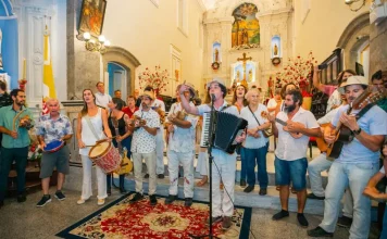Grupo de Terno de Reis se apresenta em espaço público, ilustrando a tradição cultural e a celebração do encerramento do ciclo natalino em Florianópolis.