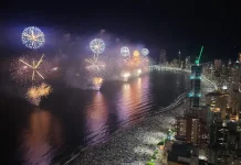 Réveillon em Balneário Camboriú reúne mais de um milhão de pessoas Imagem aérea do Réveillon em Balneário Camboriú, mostrando a queima de fogos sobre a Praia Central lotada e a orla iluminada durante a virada do ano.