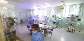 Profissionais da área da saúde atuam em ambiente hospitalar com equipamentos médicos, imagem usada para ilustrar o concurso público da Secretaria de Estado da Saúde de Santa Catarina.
