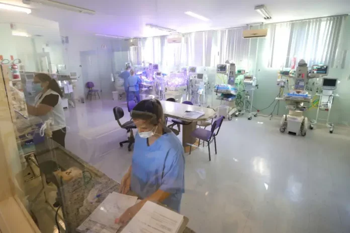 concurso da saúde Profissionais da área da saúde atuam em ambiente hospitalar com equipamentos médicos, imagem usada para ilustrar o concurso público da Secretaria de Estado da Saúde de Santa Catarina.