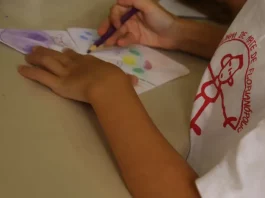 Criança pintando em aula na Escolinha de Arte da FCC