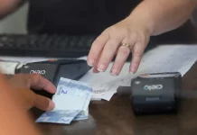 Santa Catarina sobe 21 posições no ranking nacional de liberdade econômica Pessoa realiza pagamento em estabelecimento comercial, imagem usada para ilustrar a liberdade econômica e o ambiente de negócios.