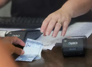 Pessoa realiza pagamento em estabelecimento comercial, imagem usada para ilustrar a liberdade econômica e o ambiente de negócios.