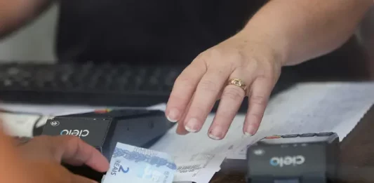 Pessoa realiza pagamento em estabelecimento comercial, imagem usada para ilustrar a liberdade econômica e o ambiente de negócios.