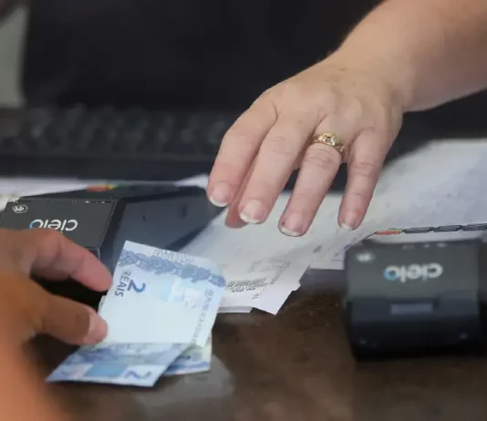 Pessoa realiza pagamento em estabelecimento comercial, imagem usada para ilustrar a liberdade econômica e o ambiente de negócios.